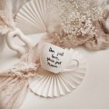 Biały kubek porcelanowy 500 ml - motyw złotego serca i napisu dom jest tam, gdzie jest mama dla mamy na Dzień Matki Zbliżenie na złote zdobienie serca na białym kubku porcelanowym Dom jest tam, gdzie jest mama nadzwyczajnie.mom