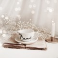 Biała filiżanka porcelanowa 250 ml ze spodkiem - motyw złotego serca z napisem Mamuś dla mamy na Dzień Matki Filiżanka porcelanowa ze złotym sercem ze spodkiem - Mamuś nadzwyczajnie.mom — widok z boku na białym tle