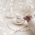 Biała filiżanka porcelanowa do espresso ze spodkiem 100 ml - napis Dzień dobry ze złotym sercem dla miłośnika kawy na urodziny Filiżanka porcelanowa ze złotym sercem espresso ze spodkiem - Dzień dobry! nadzwyczajnie.mom — widok z boku na białym tle