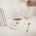Biały zestaw porcelanowy z personalizacją - Imbryk i filiżanka ze spodkiem z imionami na zakończenie roku Biały filiżanka porcelanowa nadzwyczajnie.mom ze złotym zdobieniem i napisem imbryk i filiżanka z imionami dzieci na spodku