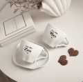 Biała Asymetryczna Filiżanka Porcelanowa ze Spodkiem 200 ml - Napis Dzień Dobry Żono ze Złotym Sercem dla Żony na Rocznicę Ślubu Zbliżenie na złote zdobienie serca na białym filiżance porcelanowej Biała Asymetryczna Filiżanka Porcelanowa ze Spodkiem