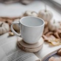 Drewniana podkładka pod kubek - motyw serduszka dla bliskiej osoby na każdą okazję Zbliżenie na złote zdobienie na białym kubku porcelanowym Podkładka drewniana pod kubek - serduszko nadzwyczajnie.mom