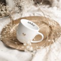 Biały kubek porcelanowy 300 ml - napis delikatność ze złotym sercem dla niej na urodziny Kubek porcelanowy ze złotym sercem delikatność nadzwyczajnie.mom — widok z boku na białym tle
