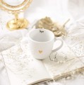 Biały kubek porcelanowy 300 ml - napis mąż ze złotym sercem dla męża na rocznicę ślubu Kubek porcelanowy ze złotym sercem Mąż nadzwyczajnie.mom — widok z boku na białym tle